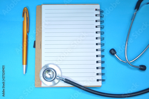 Blank notebook and medical stethoscope top view. Doctor’s work table concept. Health care concept
