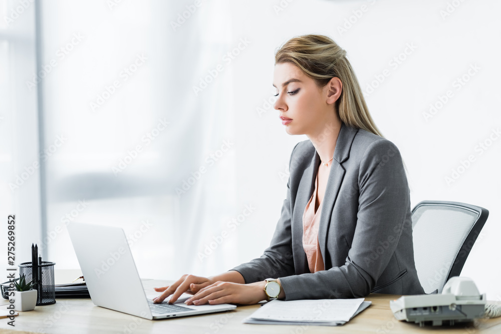 businesswoman in formal wear sitting in office and working on laptop businesswoman in formal wear sitting in office and working on laptop