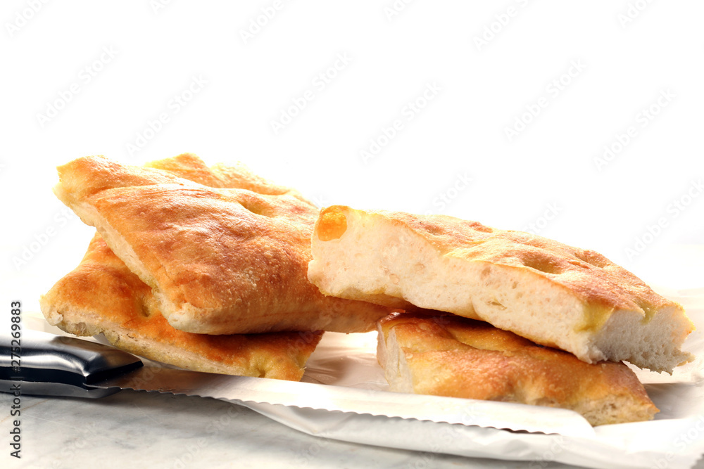 slices of traditional italian focaccia and a knife rest on a marble table with copy space for your text