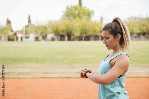 Sporty woman looking at fitnesstracker photo
