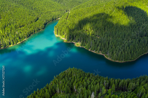 Mountain forest lake landscape. Aerial view. View on the turquoise color lake between mountain forest. Over beautiful turquoise mountain lake and green forest. National park. Green pine and fir trees photo