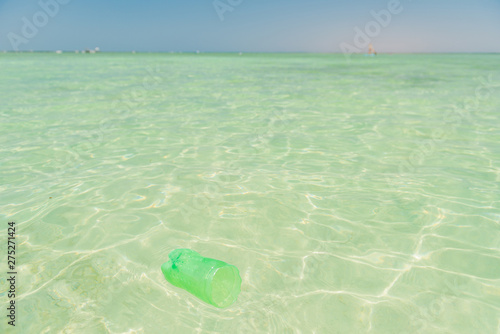 plastic bottle part flowing in clear blue sea coast water