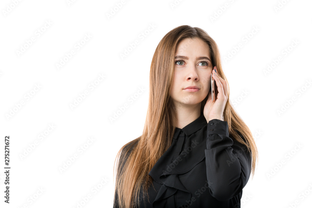 Portrait of a young caucasian woman in a black shirt and long flowing hair using hand-holding technology phone, taking a call against white isolate background Portrait of a young caucasian woman in a black shirt and long flowing hair using hand-holding technology phone, taking a call against white isolate background