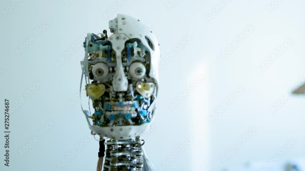 Futuristic humanoid female robot is idle. Concept of future. The head of a humanoid android humanoid robot. The robot turns his head, blinks his eyes. Android skull Futuristic humanoid female robot is idle. Concept of future. The head of a humanoid android humanoid robot. The robot turns his head, blinks his eyes. Android skull