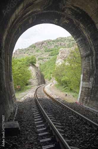 View from inside railroad tunnel outside and rails in the mountain in Bulgaria