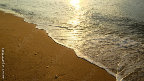 Ocean wave with goldden sunshine in the mroning at tropical peaceful beach. photo