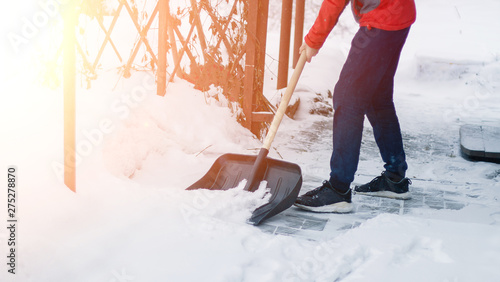 Wallpaper Mural A man cleans up, cleans snow from the sidewalk after a blizzard, snowfall. a civil servant in a snowfall with one shovel in a winter blizzard. leaning a shovel on the snow on the driveway. drifts. Torontodigital.ca