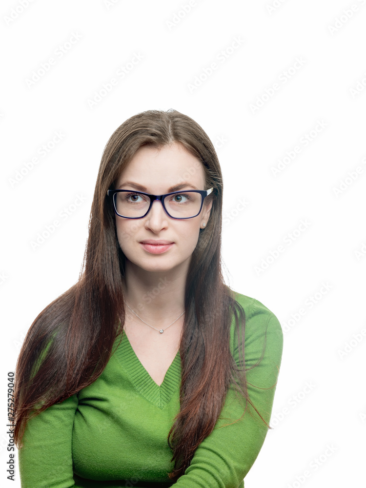 Young woman portrait. Long hired brunette female model in eyeglasses and green blouse looking  aside of camera. Head shot. Vertical studio image isolated on white. 