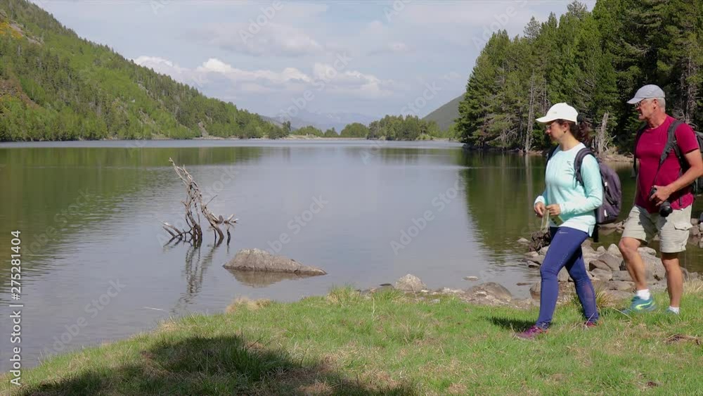 Two tourist looking a map next to the lake Two tourist looking a map next to the lake