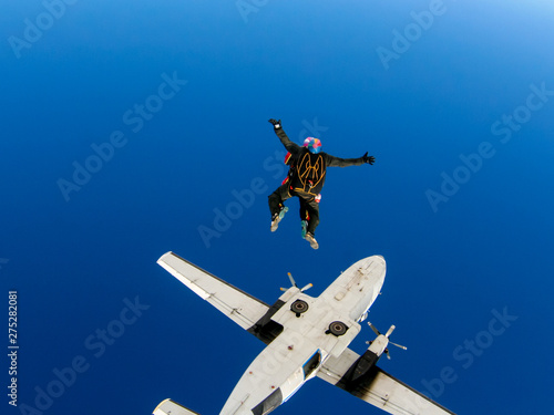 Fototapeta Naklejka Na Ścianę i Meble -  Parachute jump from an airplane in tandem with an instructor. Free fall in a cloudless blue sky.