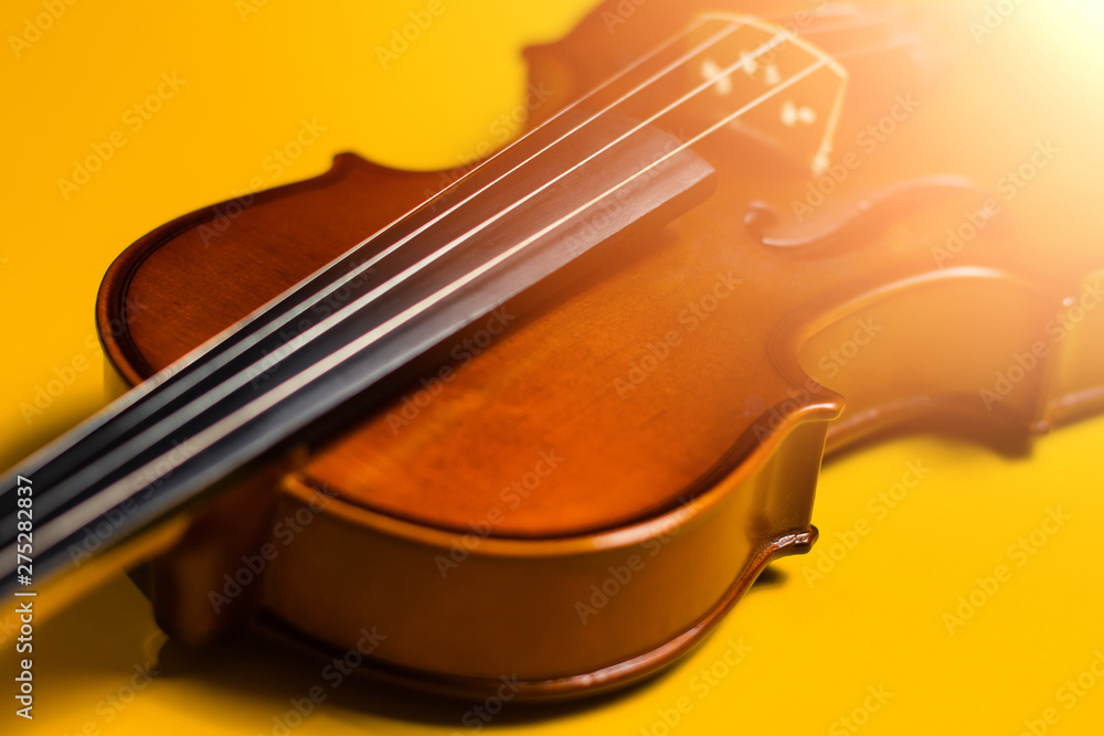 Violin with bow isolated on a yellow background. Types of musical instrument Violin with bow isolated on a yellow background. Types of musical instrument