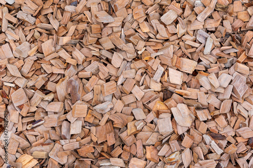 A pile of wood sawdust lies on the ground, background