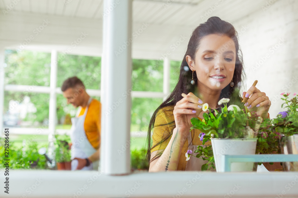 Florist standing near the window with her colleague behind. Florist standing near the window with her colleague behind.