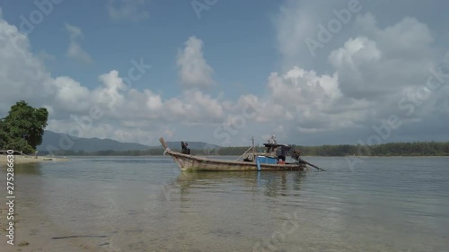 Wallpaper Mural Wide angle panning shot of a wooden fishing boat travelling through shallow waters. Torontodigital.ca