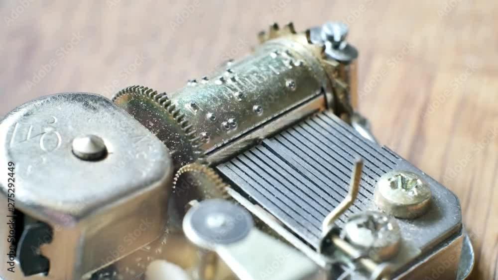 Music box clockwork mechanism close up on turning barrel & cogs. Music box clockwork mechanism close up on turning barrel & cogs.