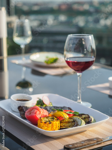 Beef steak with grilled vegetables. Dish and glass of red wine
