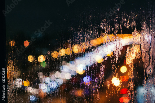 Raindrops on the window, against the backdrop of the night city. Background, screen saver, wallpaper