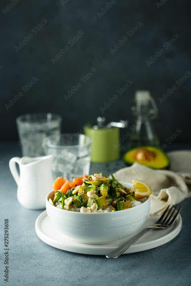 Healthy rice bowl with avocado, salmon and cashew nuts Healthy rice bowl with avocado, salmon and cashew nuts