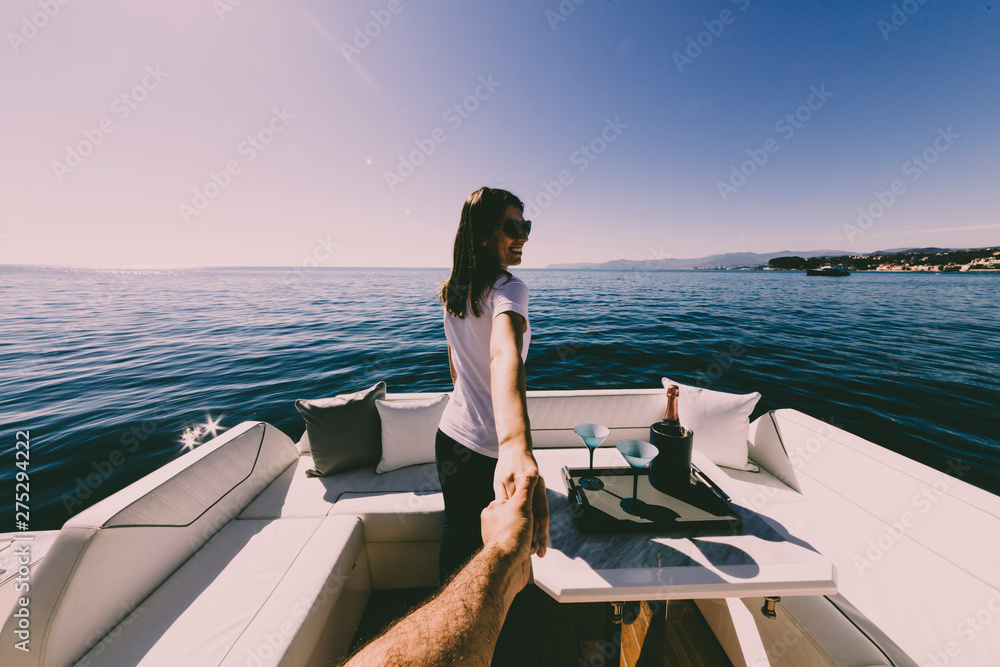 woman holding man's hand on luxury yacht