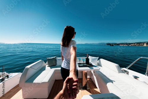 woman holding man's hand on luxury yacht © Andrea