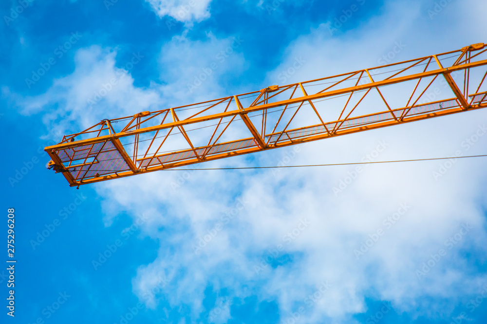 Concept photo of building construction, construction, orange cranes and scaffolding on a bright sunny day against the blue sky. Concept photo of building construction, construction, orange cranes and scaffolding on a bright sunny day against the blue sky.