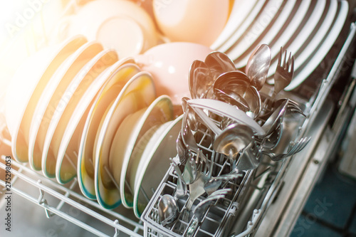 Open dishwasher with clean glass and dishes, selective focus, Clean after washing in the dishwasher. bright colorful dishes.