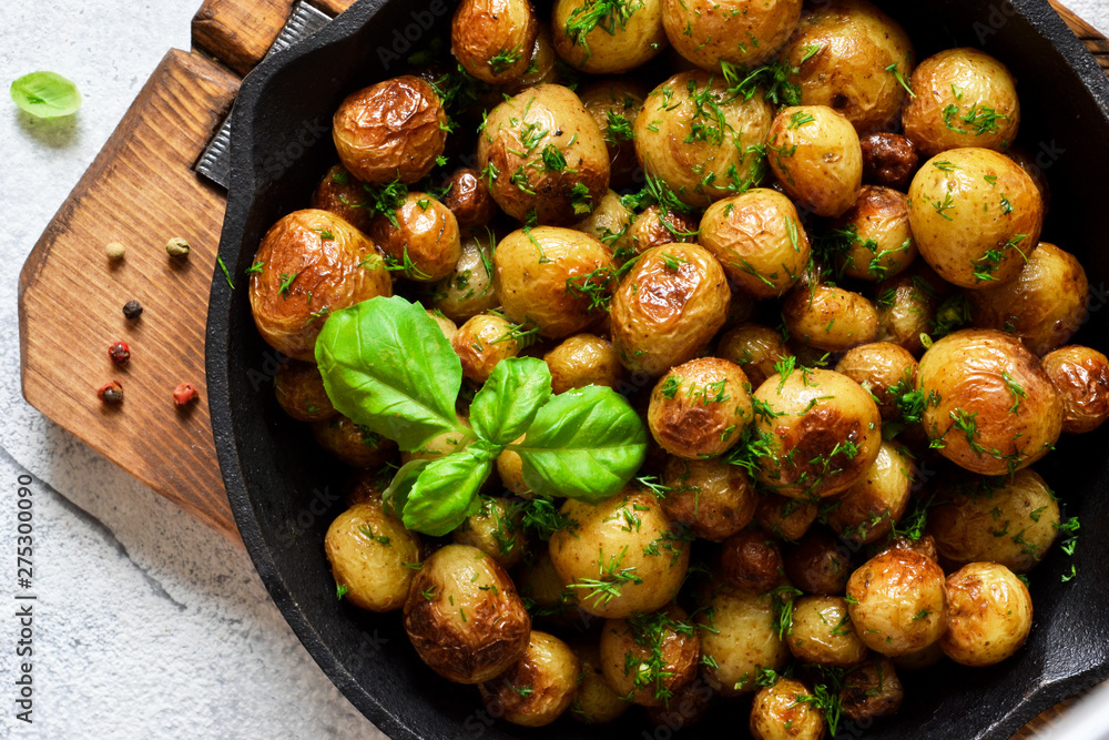 Fried, young potatoes with basil in a pan. View from above. Fried, young potatoes with basil in a pan. View from above.