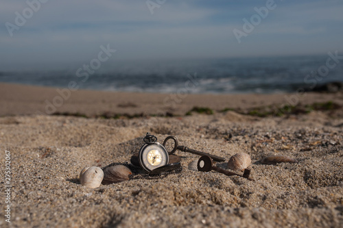 Pocket watch in sands on beach