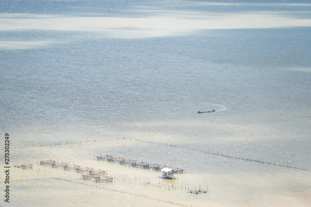Aerial view of local fishing boat and traditional fish trap with wooden floating house in the Songkhla Lake. Thailand.