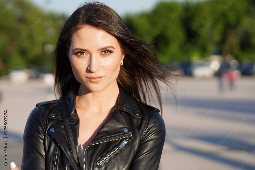 Portrait of a beautiful dark-haired Russian girl in leather jacket  outdoors. Stock Photo | Adobe Stock