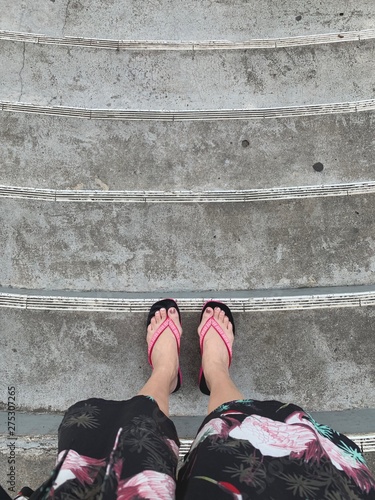 Feet on stairs with pink and black sandal