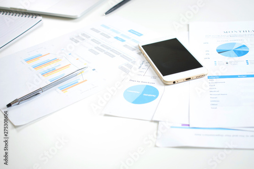 Image about financial graph Picture of a modern white desk on the table with financial documents, bar graphs and business schedules.