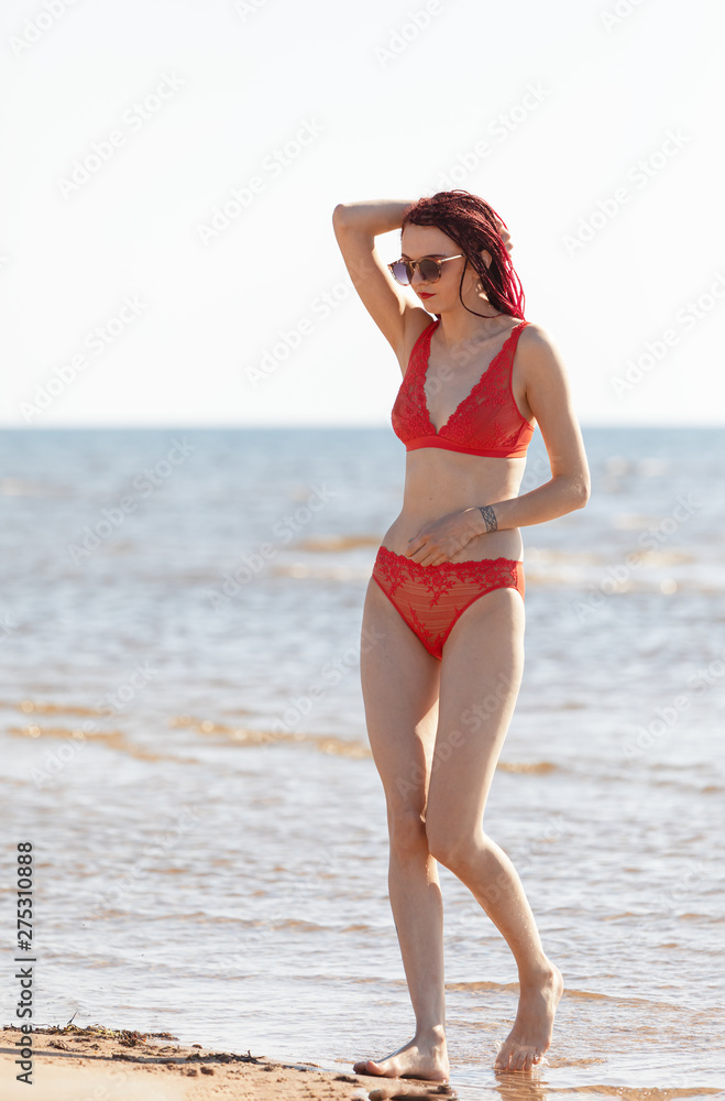 girl in a red bathing suit on the beach girl in a red bathing suit on the beach