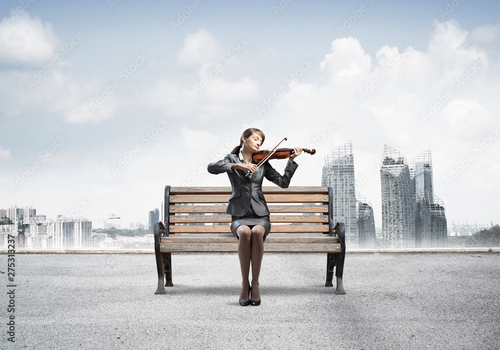 Young woman with violin sitting on wooden bench Young woman with violin sitting on wooden bench