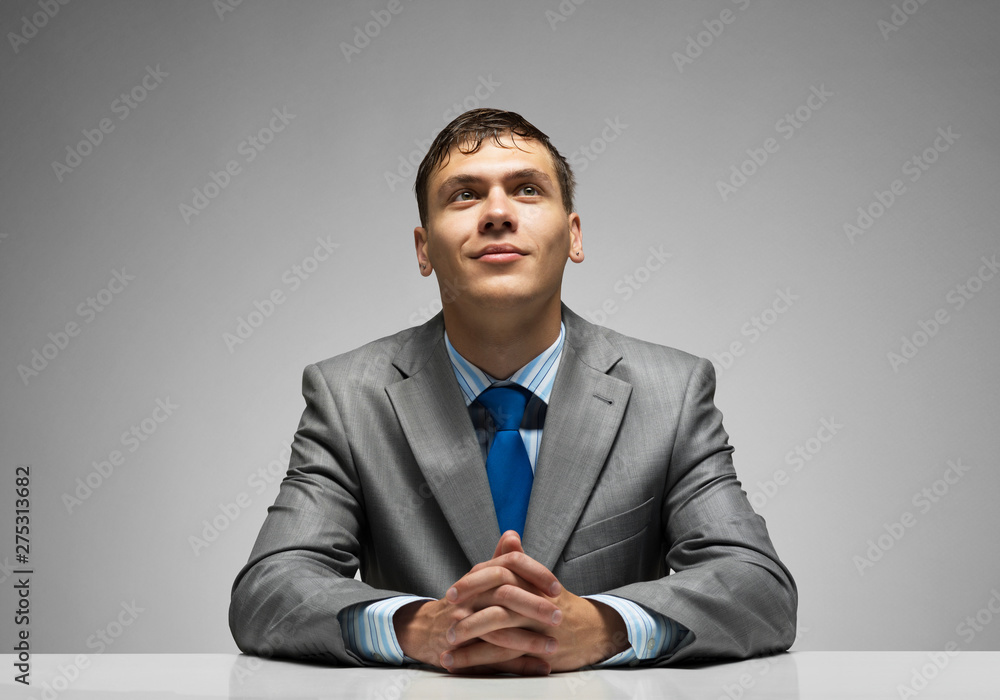 Smiling man folded hands and looking upward. Smiling man folded hands and looking upward.