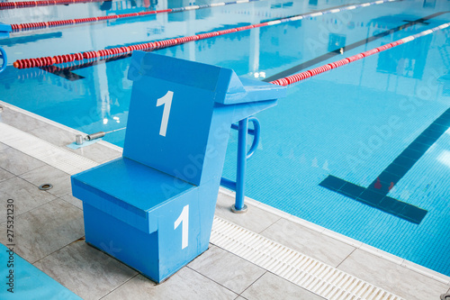 Starting block, number 1, swimming pool with an empty race track. Sport swimming photo