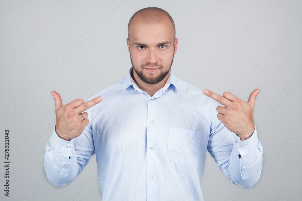 Studio shot of a bearded young man showing fuck you gesture with middle fingers, symbol of aggression. Concept of provocation. Studio shot of a bearded young man showing fuck you gesture with middle fingers, symbol of aggression. Concept of provocation.
