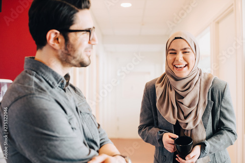 Принти на полотні Smiling coworkers discussing in corridor at workplace