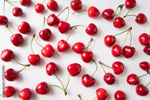 Fresh cherries scattered on white. Cherries on a white background. Fresh cherry. Cherry fruit. Cherries with copy space for text. Top view. Background of cherries.Sprinkled cherry on white background.