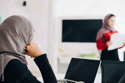 Photography Teenage girl wearing hijab listening to classmate during presentation