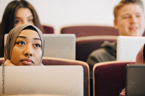 Canvas Print Serious male and female classmates listening in university lectures