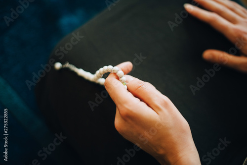 Canvas Print Cropped image of woman praying with rosary beads at home