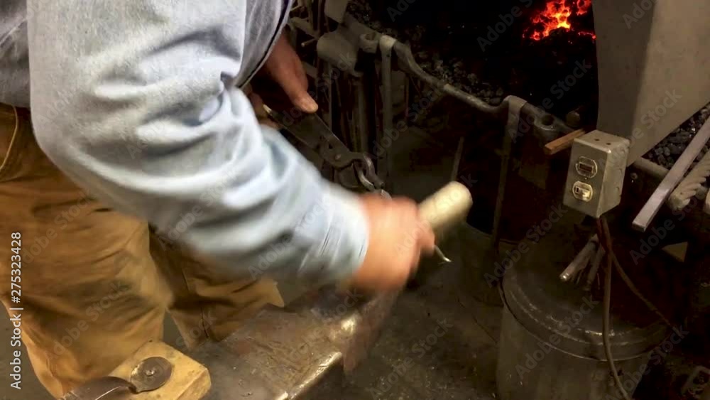 Blacksmith wire brushes polishes metal anvil Blacksmith wire brushes polishes metal anvil