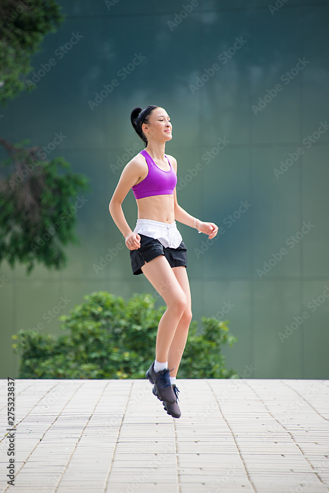 Fitness girl exercising outdoor in urban city architecture, stretching legs, doing squash, push-buttons, jumps, resting, smiling athlete body Fitness girl exercising outdoor in urban city architecture, stretching legs, doing squash, push-buttons, jumps, resting, smiling athlete body