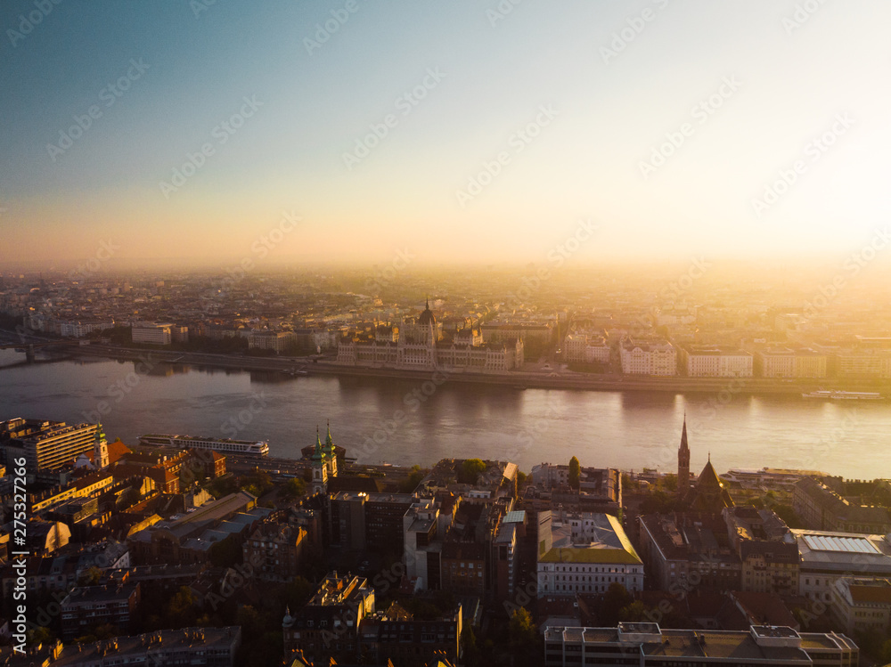 Aerial view onto Hungarian Parliament Building from above in front of Danube river during sunrise in Budapest in autumn with sunshine (Budapest, Hungary, Europe)
