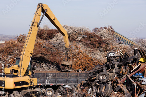 Excavator Moving Scrap Metal with Electro Magnet photo