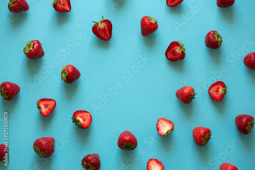 Top view on strawberry frame on blue background. Summer nature background. Berries pattern. Flat lay