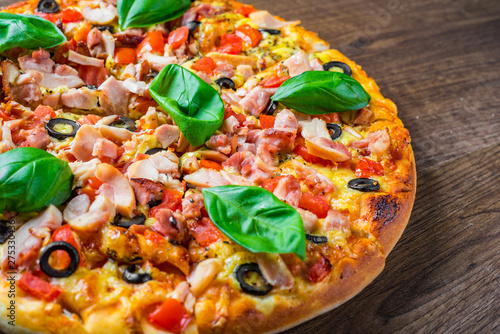 Pizza with Chicken meat, Mozzarella cheese, tomato, olive. Italian pizza on wooden background