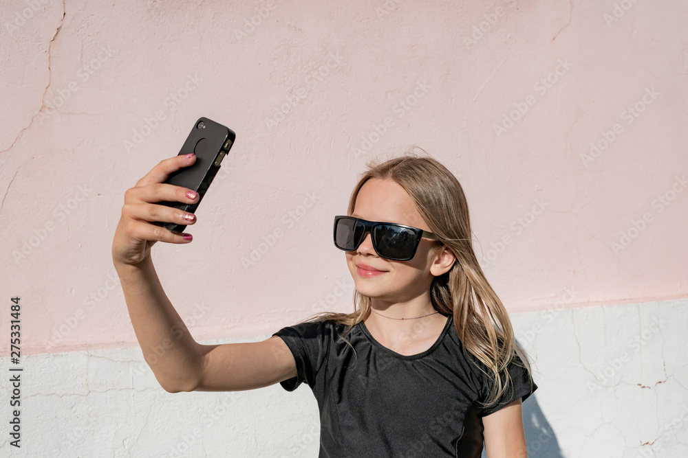 Fototapeta premium Teen girl with glasses with phone