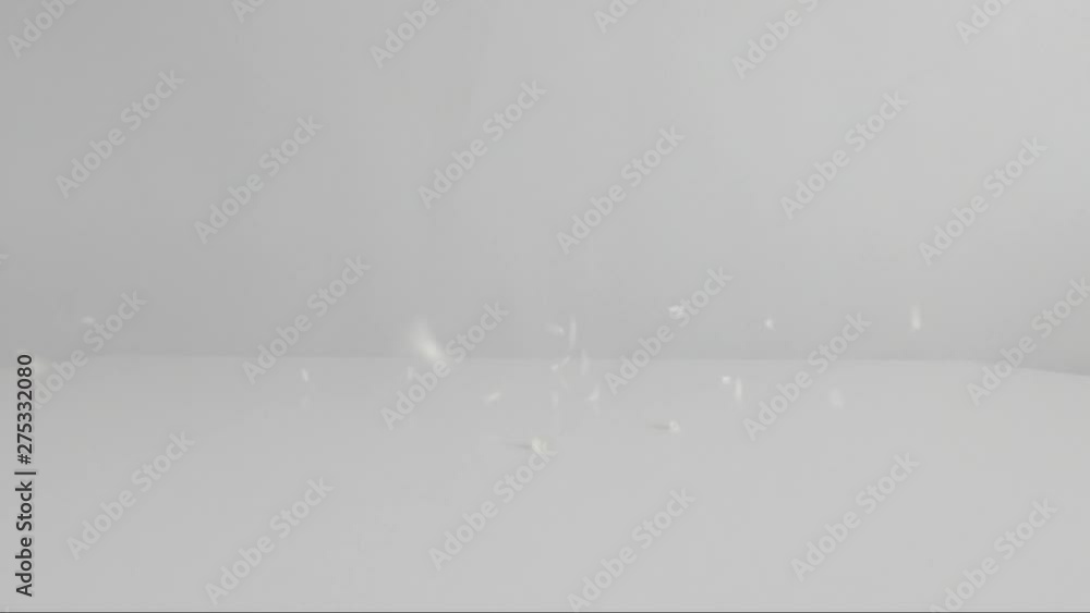 Slow motion of white rice falling on a table Slow motion of white rice falling on a table